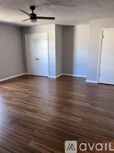 A room with wooden flooring and a ceiling fan.
