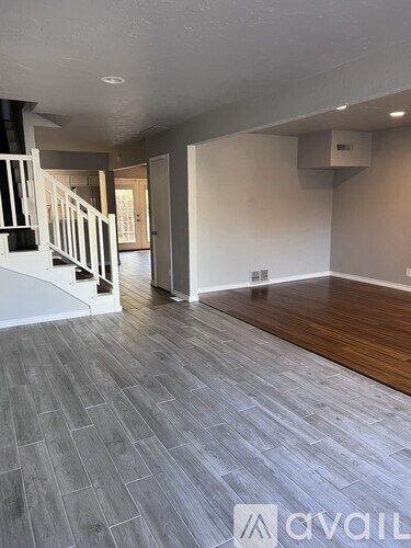 A room with a staircase and a wooden floor.