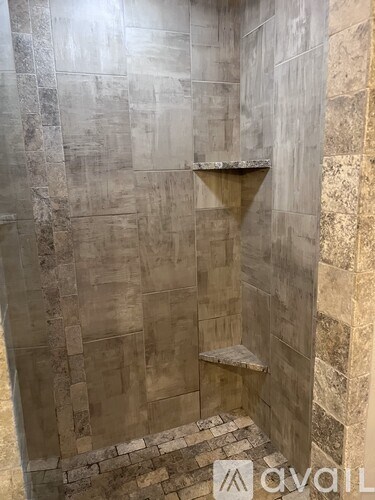 A tiled shower with a bench seat.