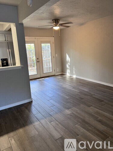 A room with a ceiling fan and wooden flooring.
