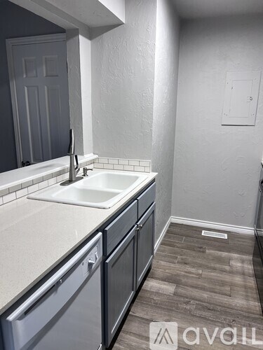 A small white sink is in a small kitchen.