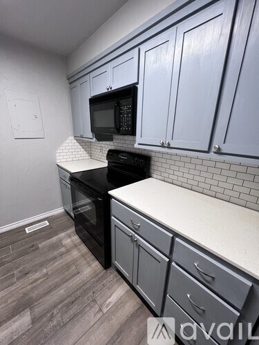 A kitchen with a black oven and microwave.