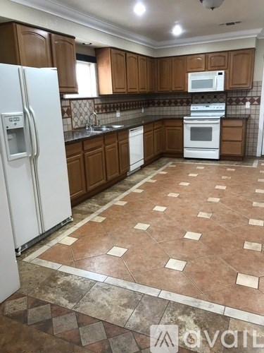 A kitchen with brown cabinets and a white fridge.