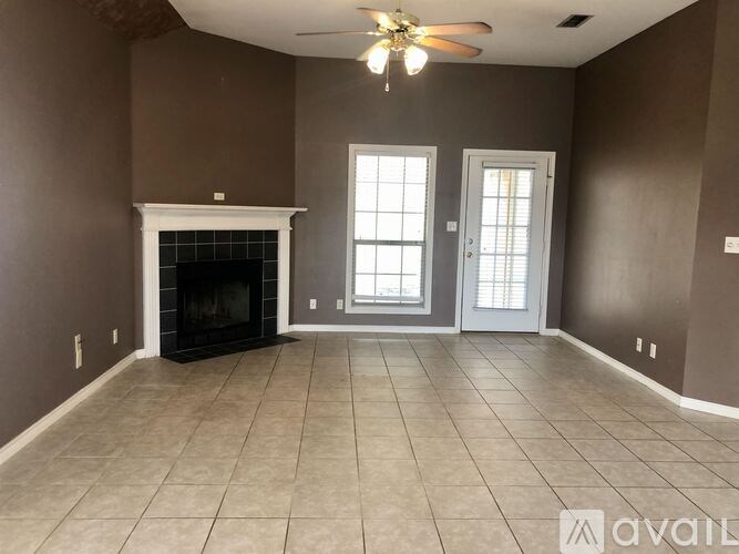 A room with a fireplace and a ceiling fan.