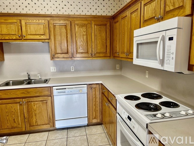 A kitchen with wooden cabinets and a white microwave.