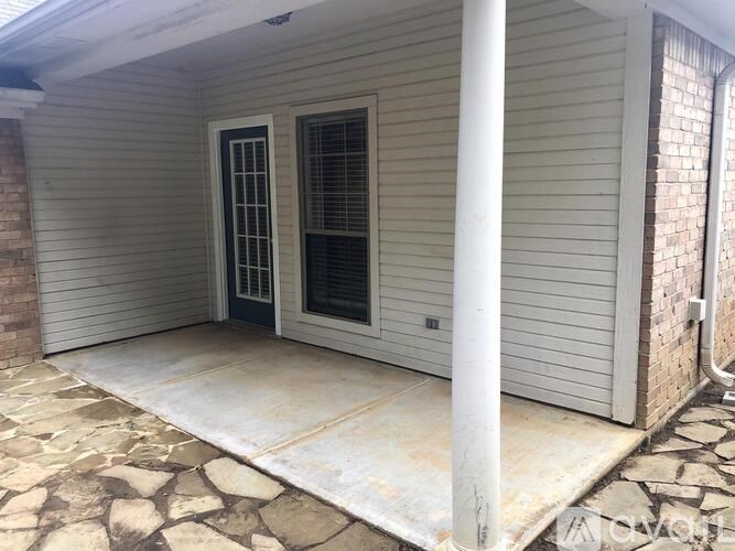 A white house with a grey door and a window.
