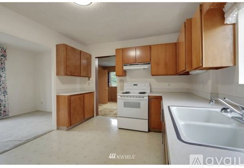 A kitchen with a white oven and brown cabinets.