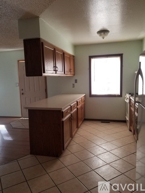 A kitchen with brown cabinets and a white counter.