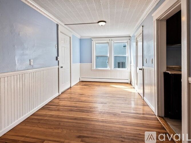 A long hallway with wooden floors and white walls.