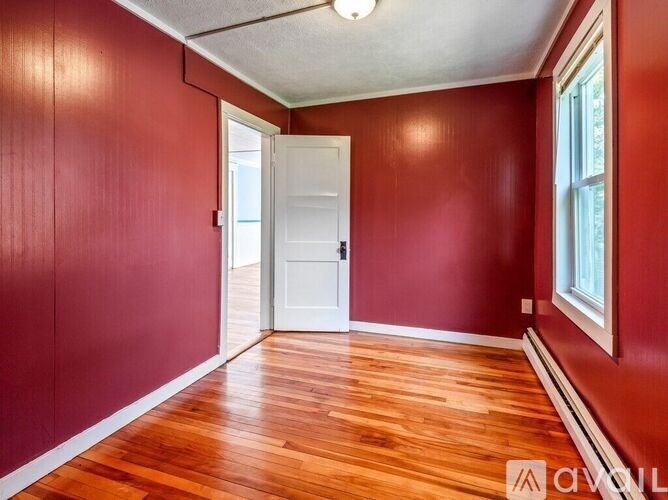 A room with red walls and wooden flooring.