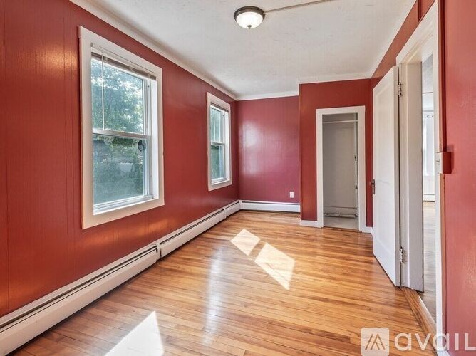 A room with red walls and wooden flooring.