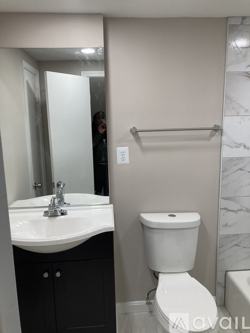 A bathroom with a sink, toilet and mirror.