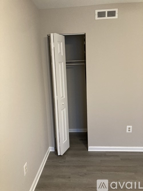 A room with a white door and a wall socket.