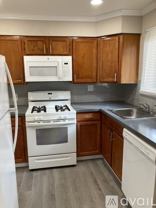 A kitchen with wooden cabinets and a white fridge.