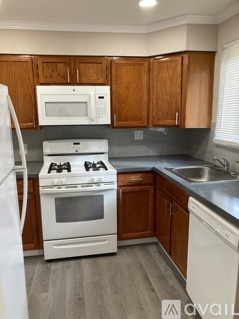A kitchen with wooden cabinets and a white fridge.