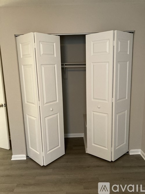 A white wardrobe with two doors is open.