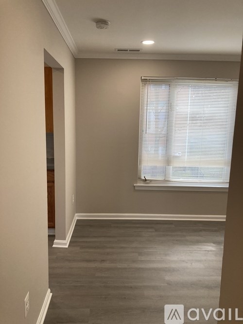 A room with a window and a wooden door.