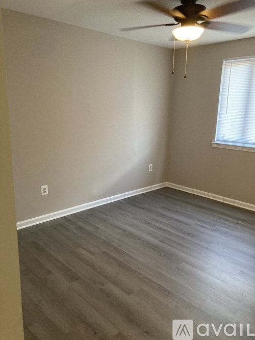 A room with a ceiling fan and a window.