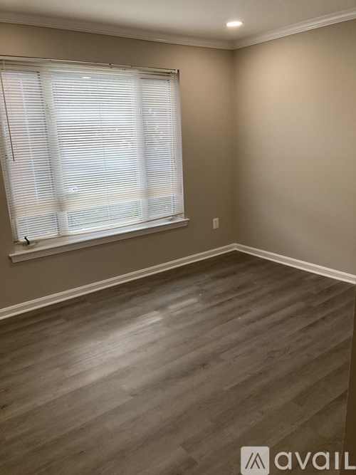 A room with a window covered by white blinds.