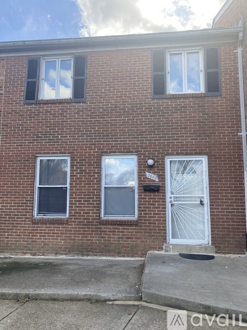 A red brick house with a white door and windows.
