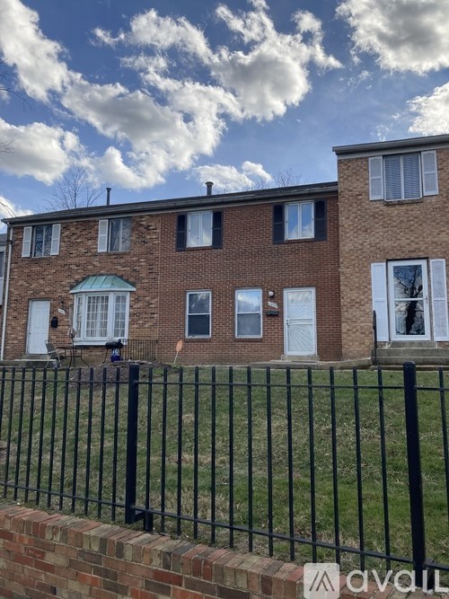 A brick house with a black fence in front.
