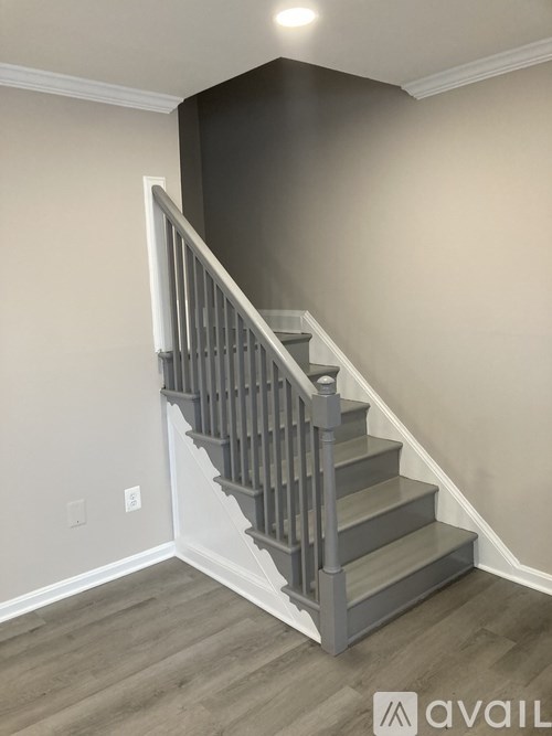 A staircase with a wooden handrail and steps leading up to a second floor.