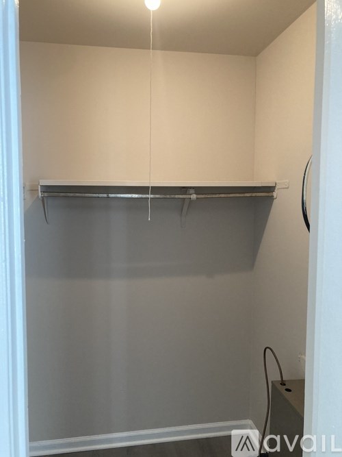 A small, empty room with a shelf and a power outlet.