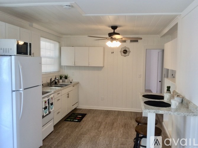 A kitchen with white cabinets and a refrigerator.