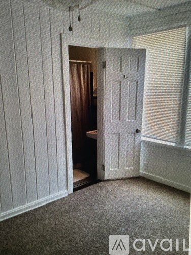 A room with a carpeted floor and a white door.