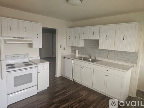 A kitchen with white cabinets and a stove top oven.