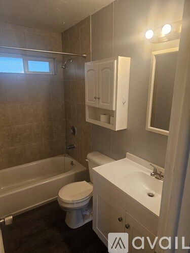 A bathroom with a toilet, sink, and bathtub.