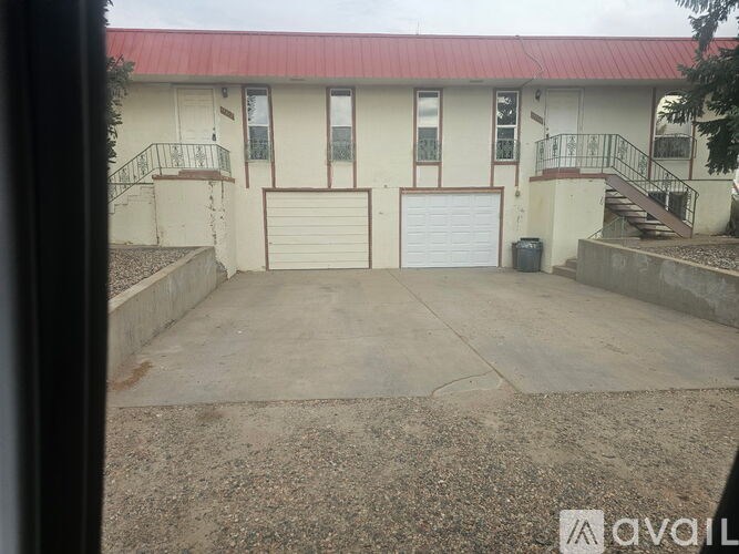 A two-story house with a red roof and white walls.