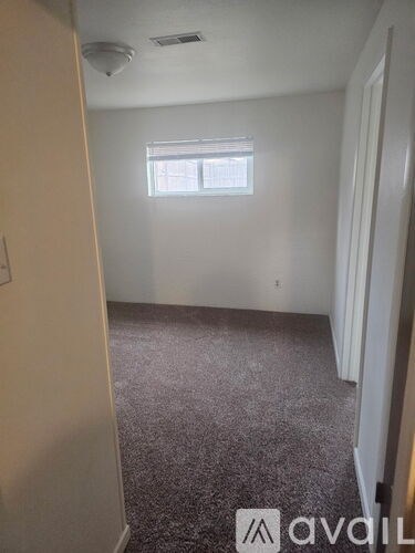 A room with a carpeted floor and a window.
