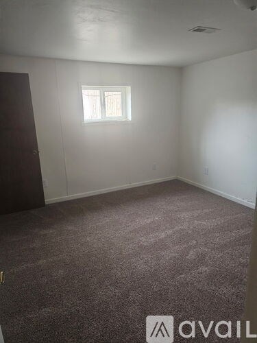A room with a carpeted floor and a window.