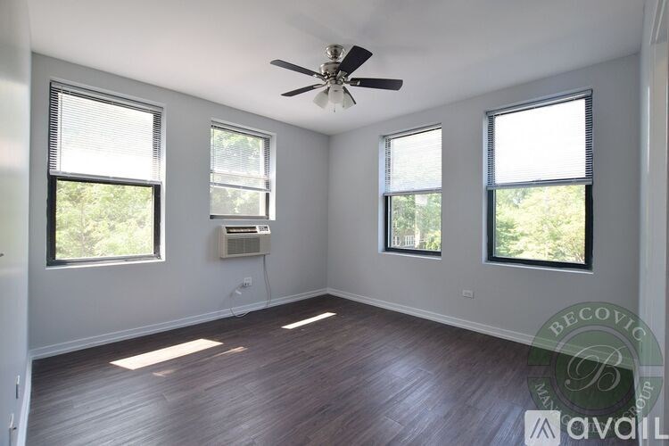 A room with a ceiling fan and three windows.