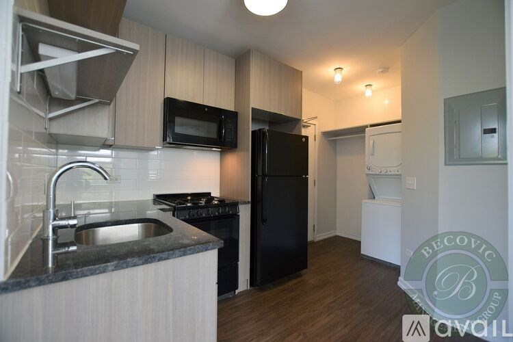 A kitchen with a black refrigerator and a white sink.