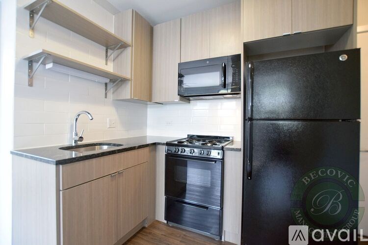 A kitchen with a black fridge and a stove with an oven.