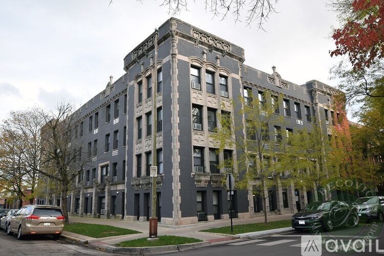A grey building with a tree in front of it.