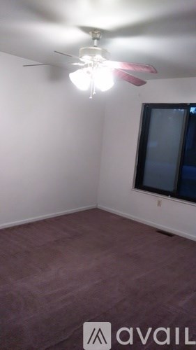 A room with a ceiling fan and a window.