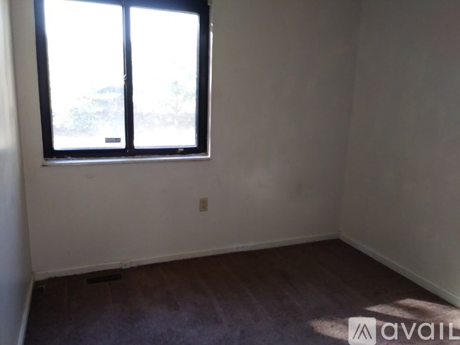 A room with a window and wooden flooring is available.