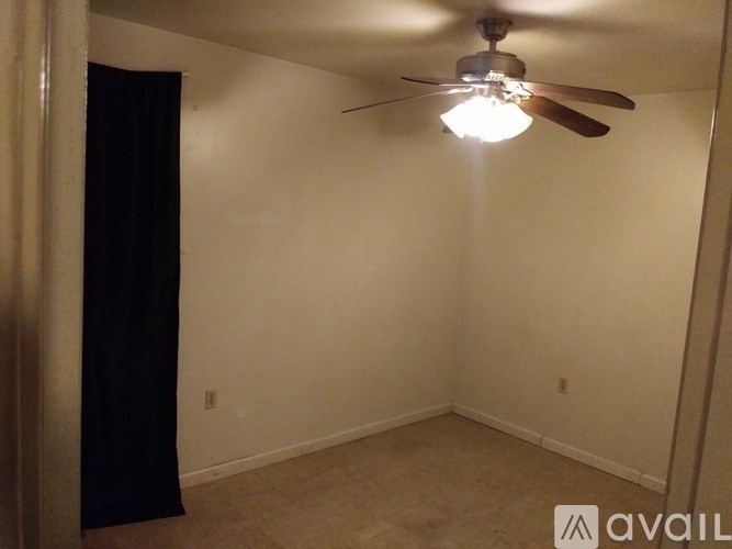 A room with a ceiling fan and a light fixture.