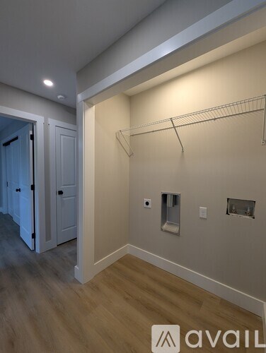 A room with a white wall and a wooden floor.