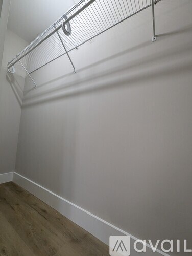 A white wall with a metal rack on top.