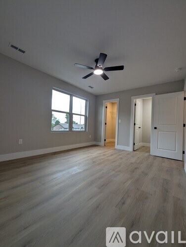 A room with a ceiling fan and a window.