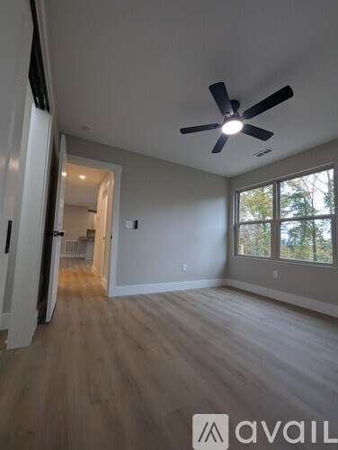A room with a ceiling fan and wooden flooring.