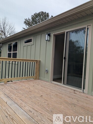 A deck with a sliding glass door and a window.