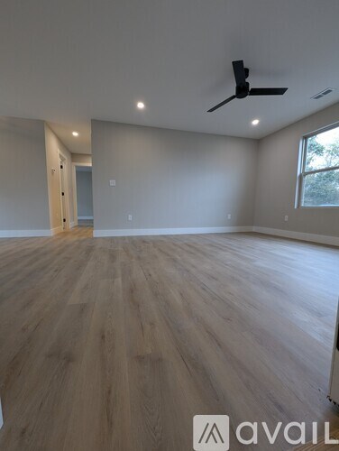 A room with wooden flooring and a ceiling fan.
