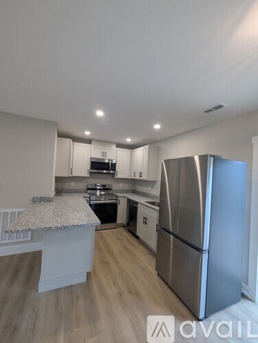 A kitchen with a granite countertop and stainless steel appliances.