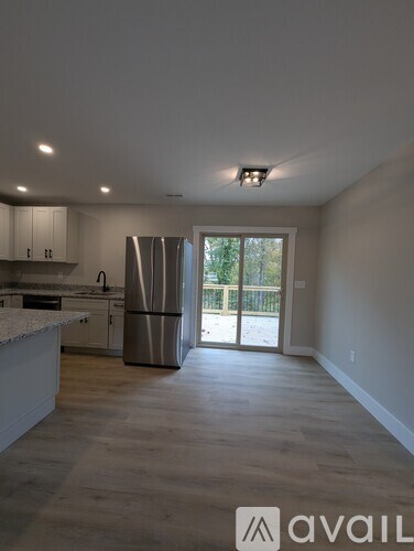 A kitchen with white cabinets and a stainless steel refrigerator.