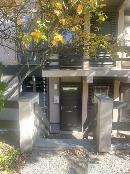 A building entrance with a black door and a metal railing.